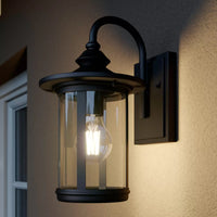 A modern black outdoor wall lantern mounted on a home's exterior showcasing elegant design.