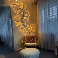 Decorative led wall light featuring a twig tree with lights indoors