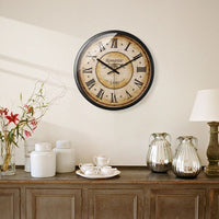 A decorative vintage wall clock hanging in a living room