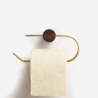 brushed brass toilet roll holder mounted on wall