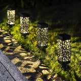 Solar garden lights illuminating a pathway in an outdoor garden setting