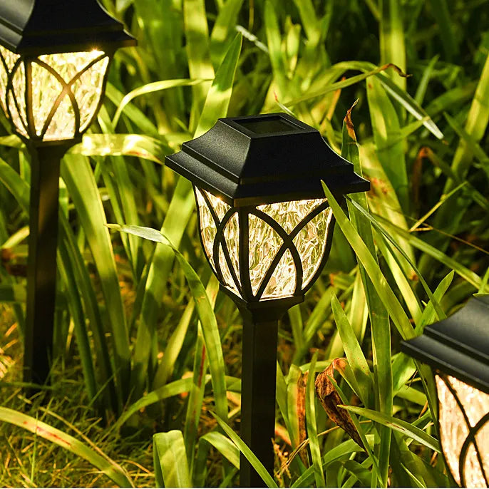 A display of solar garden lights and solar path lights illuminating an outdoor pathway