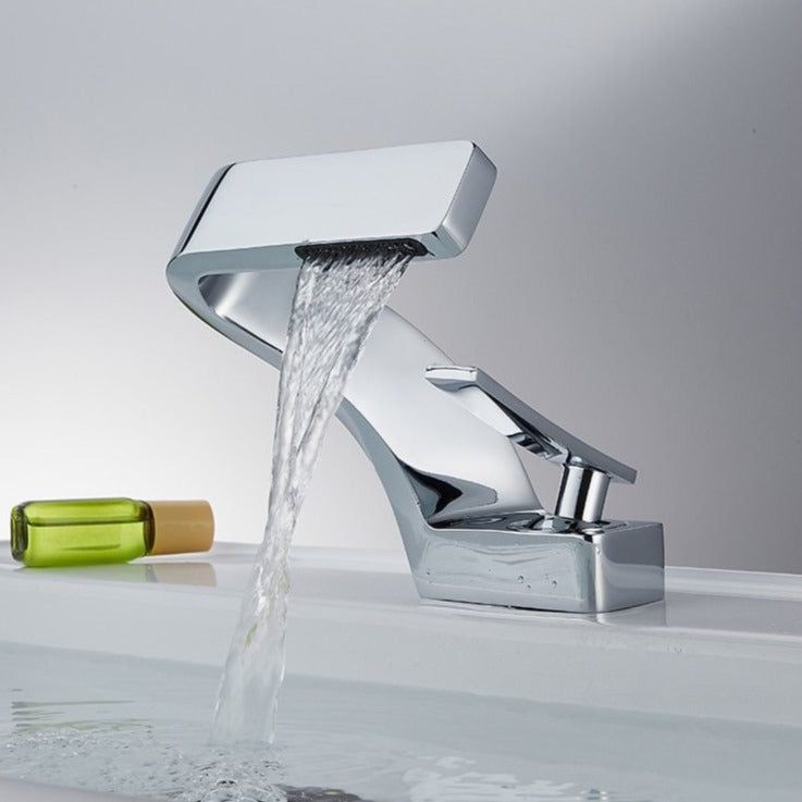 A sleek chrome waterfall bathroom tap installed on a bathroom sink