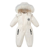 A toddler wearing a snowsuit surrounded by baby clothes and winter jacket options